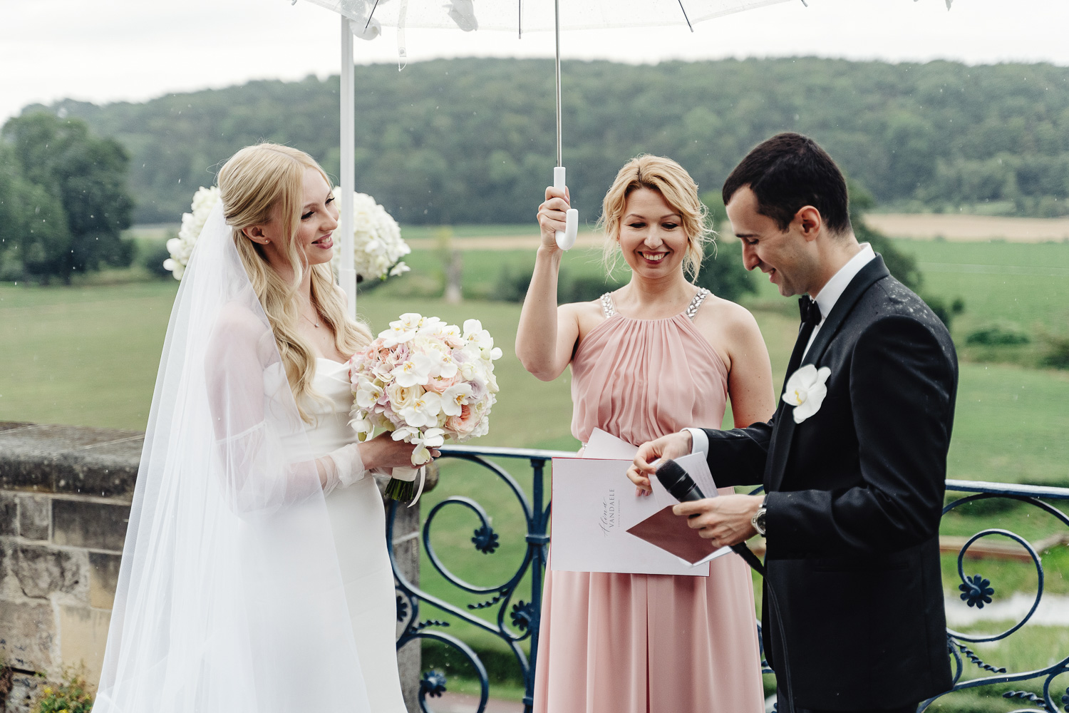 Weddingh знаменитость держит зонтик над парой и произносит речь, жених и невеста меняют клятвы. На заднем плане живописные виды на виноградники