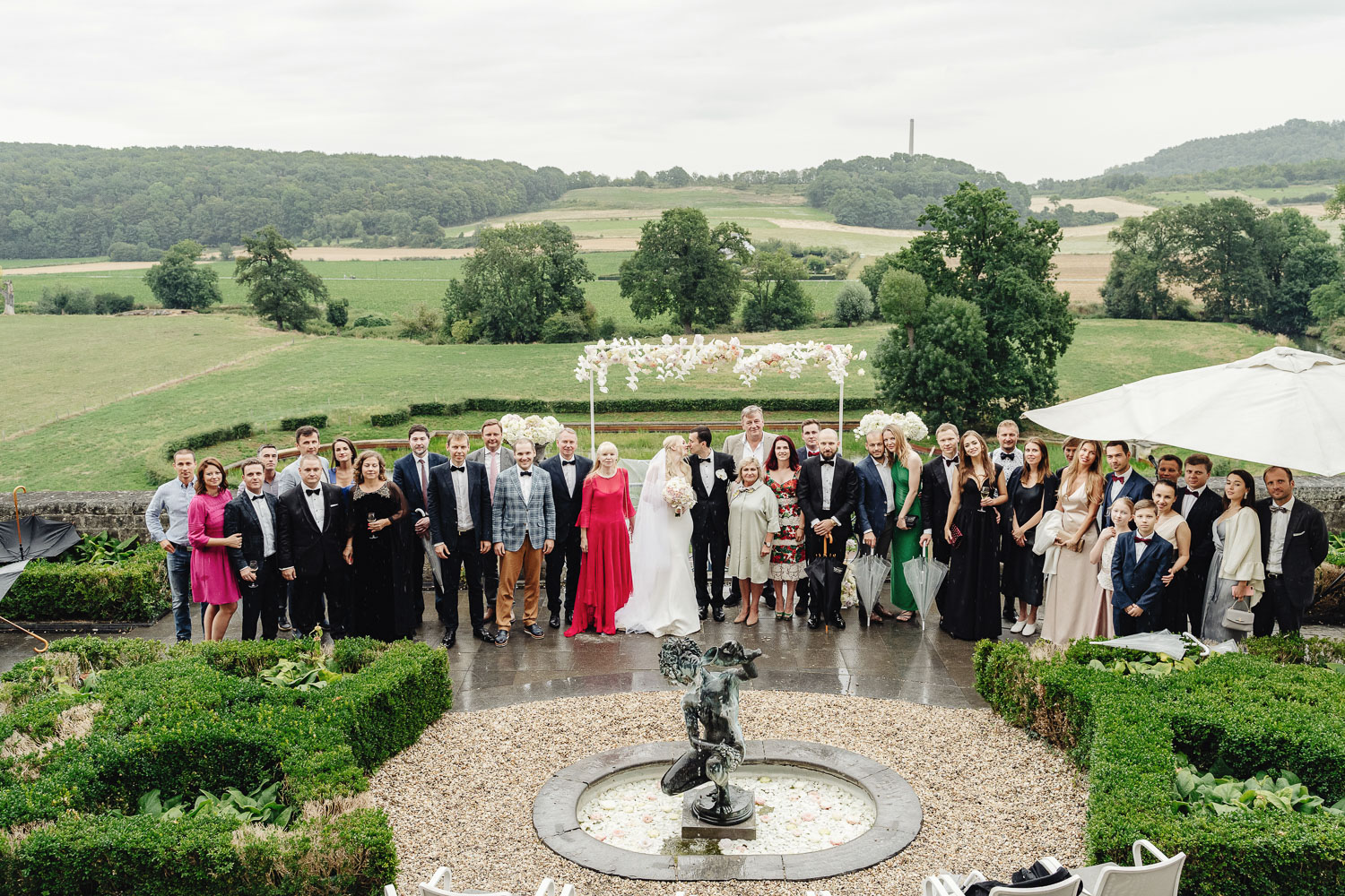 Гости позируют после свадебной церемонии на террасе Chateau Neercanne