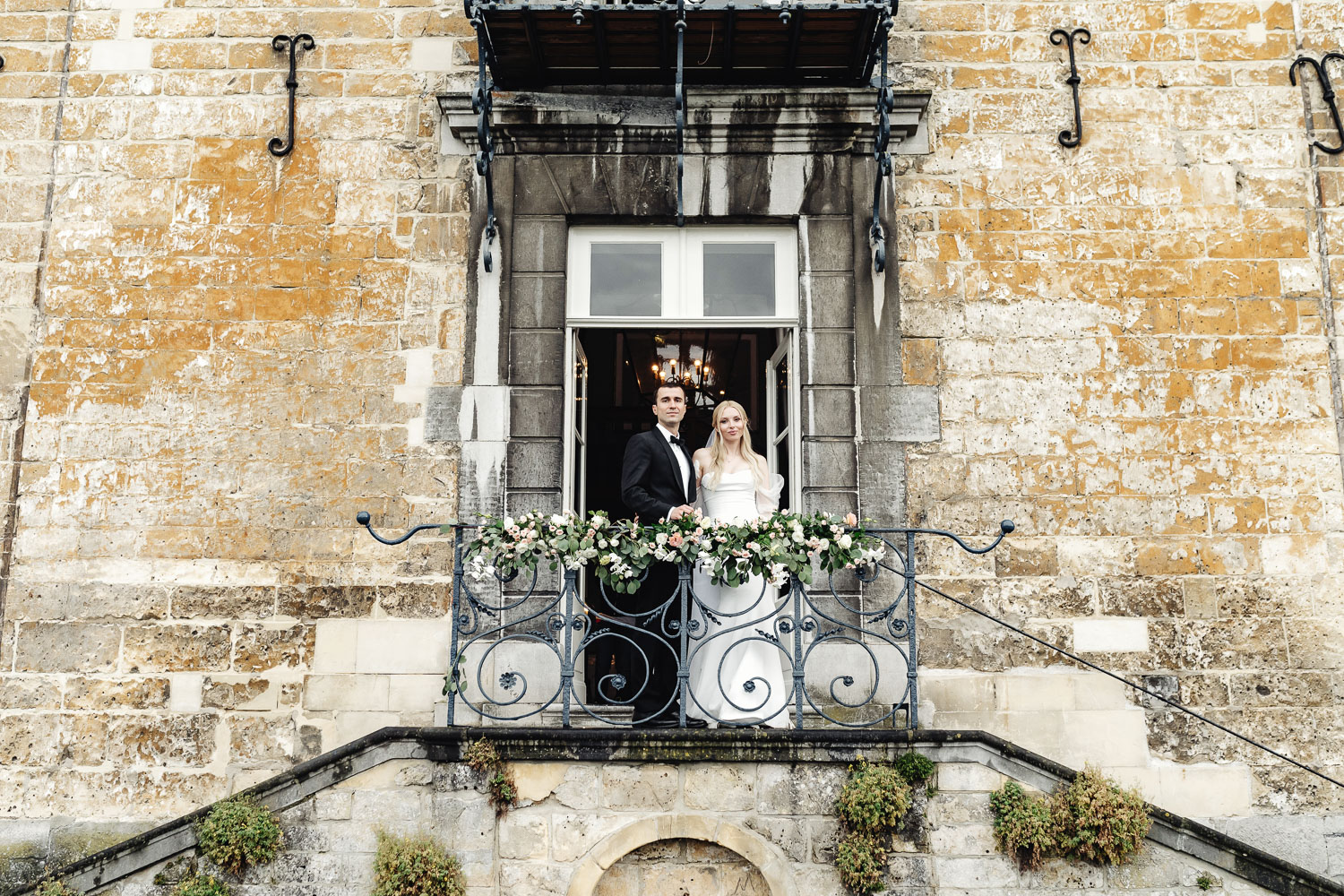 Bride and groom staying at the balcony of castle Chateau Neercanne